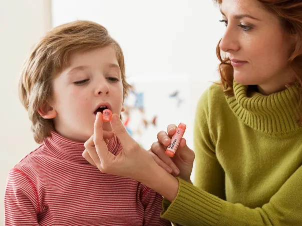Une mère donnant un traitement homéopathique à son enfant